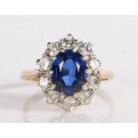 9 carat gold ring set with a central oval blue paste stone and surrounded by a band of clear