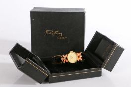 A 9 carat gold bracelet watch by Roy King, having a simple round gold watch face framed by coral and