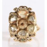 A 19th Century yellow metal and diamond ring with carved detailing to the shoulders and mount, the