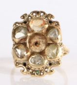 A 19th Century yellow metal and diamond ring with carved detailing to the shoulders and mount, the