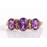 9 carat gold, amethyst and diamond ring, the three oval amethyst interspersed by two small diamonds,