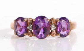 9 carat gold, amethyst and diamond ring, the three oval amethyst interspersed by two small diamonds,