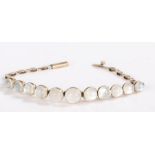 A yellow metal bracelet set with eleven moonstone cabochons in a graduating order, approximately