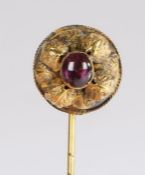 A Victorian cabochon cut amethyst set stick pin, the central amethyst with leaf scrolls, the rear of