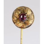 A Victorian cabochon cut amethyst set stick pin, the central amethyst with leaf scrolls, the rear of