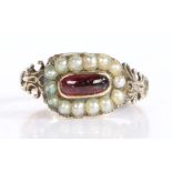 Antique seed pearl and garnet set memorial ring, the central oval garnet surrounded by a band or