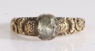 An 18th Century single diamond ring, having a rose cut diamond to the centre and a carved shank of