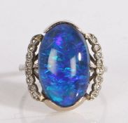 Black opal and diamond ring, the central oval opal flanked by pierced arched shoulders each set with