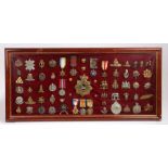 Framed display of Medals and Badges including a WW1 Trio, Atlantic Star, Africa Star, 1939-45