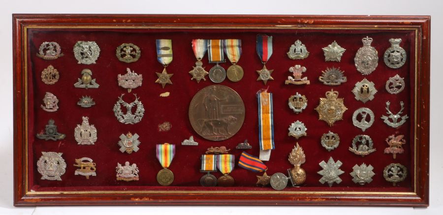 Framed display of Medals and Badges, including a WW1 Trio to 15338 PTE. E CUTTS. LINCS. R., who also