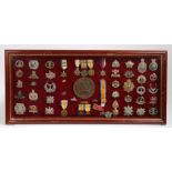 Framed display of Medals and Badges, including a WW1 Trio to 15338 PTE. E CUTTS. LINCS. R., who also