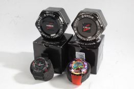 Two Casio G-Shock GA-100 gentleman's wristwatches, in black and polychrome, both with tins and outer