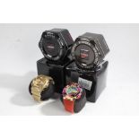 Two Casio G-Shock GA-100 gentleman's wristwatches, in gold and polychrome, both with tins and