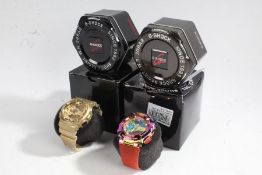 Two Casio G-Shock GA-100 gentleman's wristwatches, in gold and polychrome, both with tins and