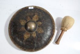 Burmese brass gong, centred with a boss and gilded design, with mallet, the gong 33cm diameter (2)