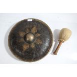 Burmese brass gong, centred with a boss and gilded design, with mallet, the gong 33cm diameter (2)