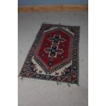Turkish prayer rug, the red blue and cream ground set with multiple guls and a repeating border,