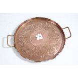 An Art Nouveau copper tray, decorated with leaves and vines and with a beaten frilled edge and