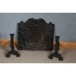 Heavy cast iron fire back, centred with with two figures, 64cm wide, 59cm high, with a pair of