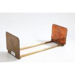 An Art Nouveau copper and brass adjustable book slide, the ends decorated with a floral motif,