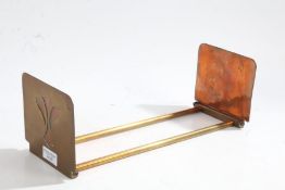 An Art Nouveau copper and brass adjustable book slide, the ends decorated with a floral motif,