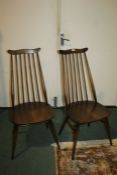 Pair of mid 20th century Ercol chairs, baring label and stamp to underside of seat, with a wavy