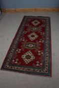 Middle Eastern style runner rug, the red and cream ground set with five guls and multiple