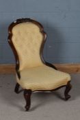 Victorian mahogany and upholstered nursing chair, with a foliate carved cresting rail above a button
