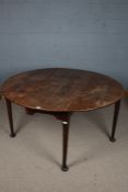 A 19th century oak drop leaf table, the top with two semi circular drop leaves above tapering legs