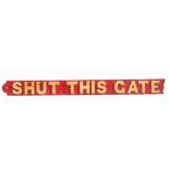 A red & gold painted cast iron sign, 'SHUT THIS GATE', of rectangular form with relief letters,