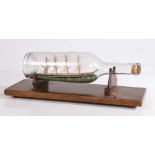 Early 20th Century ship in a bottle, the four masted ship on choppy seas, on a mahogany stand, 35.