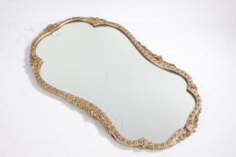 20th century gilt mirror, decorated with a floral and shell design on a wavy frame set with a