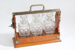 20th century golden oak tantalus, housing three cut glass decanters, 36cm wide