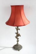 Cast brass table lamp, with floral column and circular base decorated with swags, raised on three