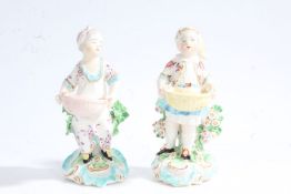 A near pair of Derby 19th Century porcelain figures depicting a young boy and girl each holding a