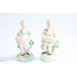 A near pair of Derby 19th Century porcelain figures depicting a young boy and girl each holding a