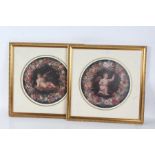 A pair of circular prints depicting cherubs on a black ground with a bouquet of flowers decorating