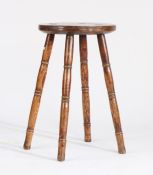 Elm stool/candle stand, the circular seat raised on four turned legs, 33cm diameter, 55.5cm high