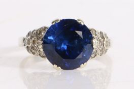 9 carat white gold ring, set with a central blue stone and paste stones to the shoulders, 4.6 grams,