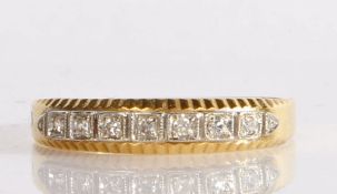 18 carat gold and diamond eternity ring, having a line of nine millegrain set diamonds in a white