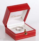 A Cartier platinum wedding band, D form, signed, 8 grams, ring size J, in original box