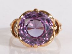 A purple stone set ring, the circular facetted stone within a yellow metal shank, 5.6 grams, ring