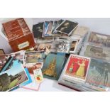 Two albums of postcards, some early 20th century examples, mostly coloured, a box of modern