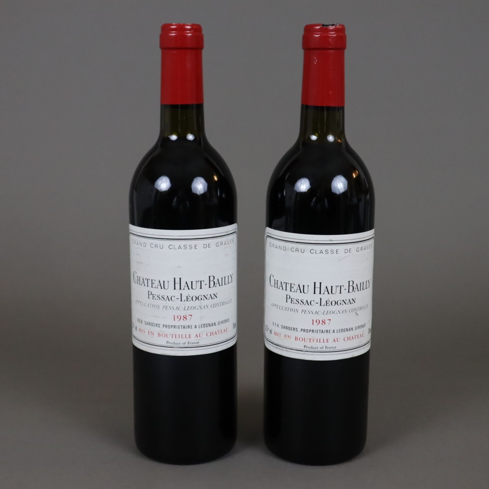 Weinkonvolut - 2 Flaschen, Château Haut Bailly 1987, Pessac-Léognan, je 0,7 Liter, Banderole leicht