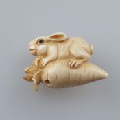 Miniatur-Netsuke - Japan, ca. Taishō-Zeit, feine Elfenbeinschnitzerei, Onyxaugen, Häschen auf Rübe,