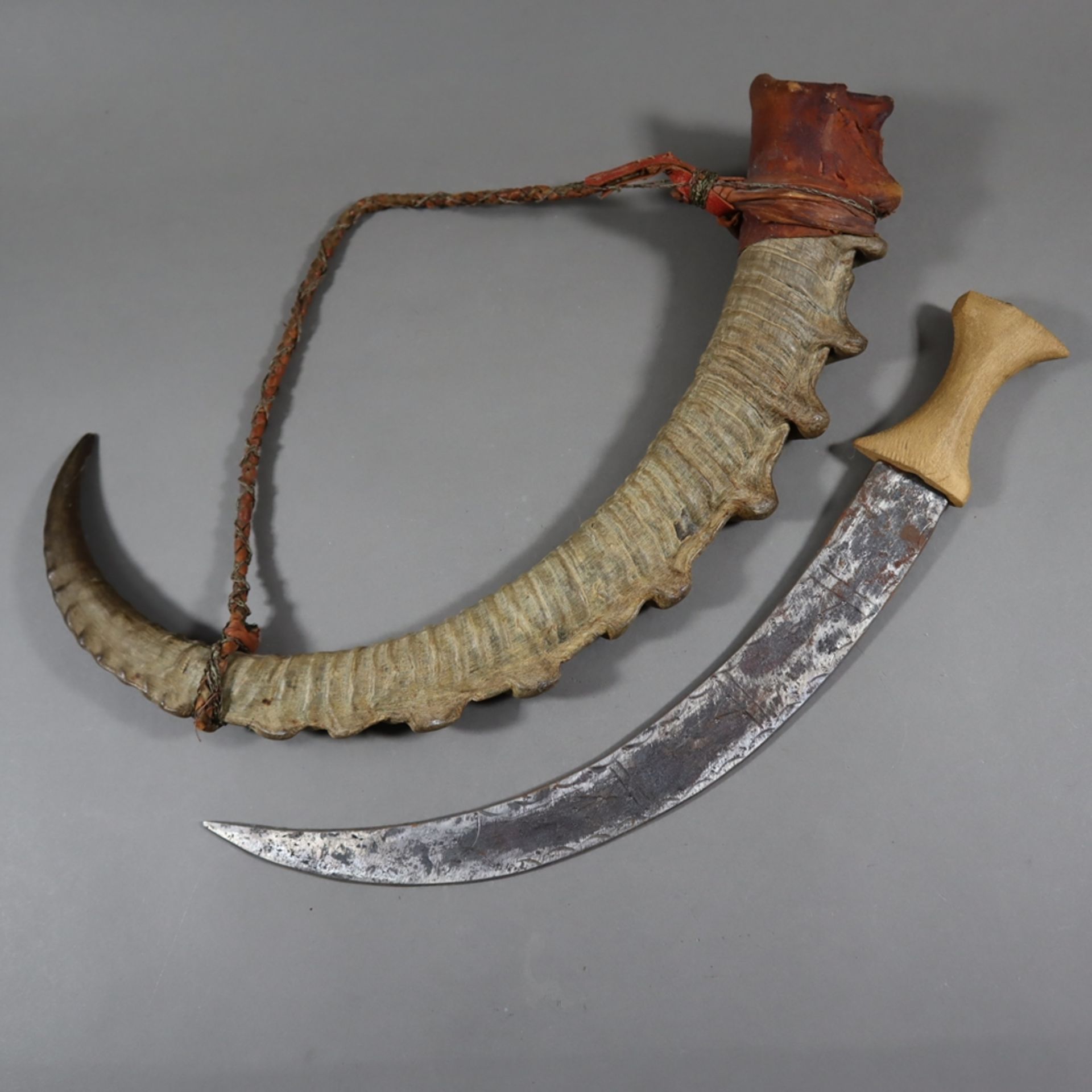 Krummdolch mit Hornscheide - afrikanisch, gekrümmte Klinge mit gravierter Ornamentik, Holzgriff lei