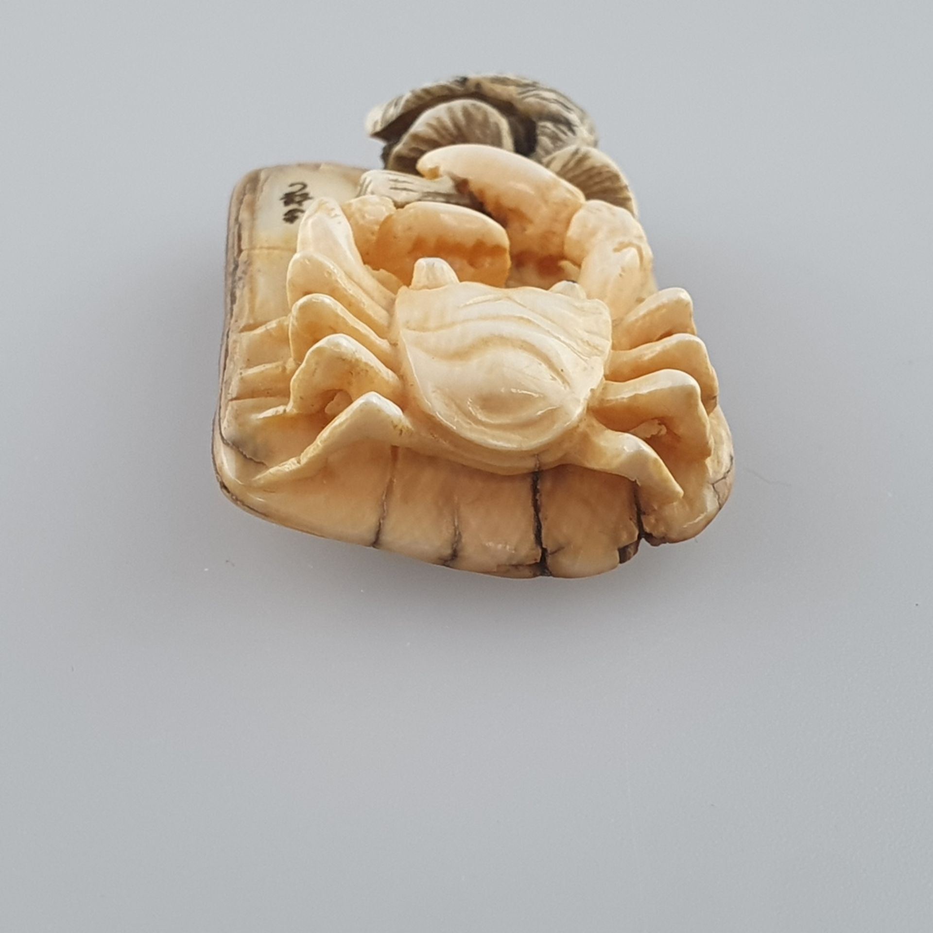 Netsuke - Mammutbein geschnitzt, graviert und teils eingefärbt, Krabbe mit Fisch, signiert, Hi - Image 3 of 6