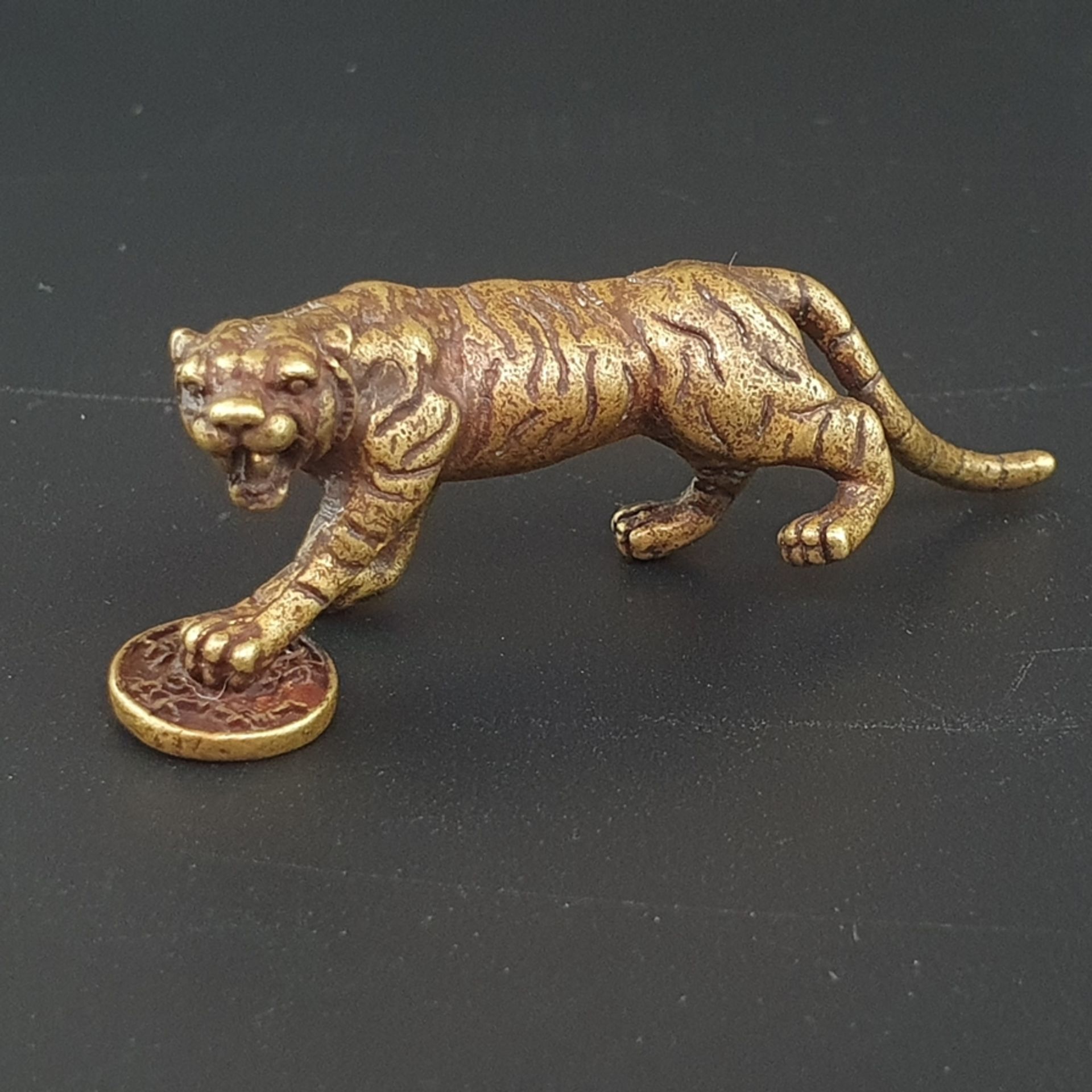 Feine Miniaturfigur "Fauchender Tiger mit Käsch-Münze" - Bronzelegierung, ca. 60 x 20 mm, ca.27 g, 