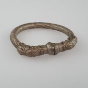 Armreif im archaischen Stil - Metall, wohl Bronzelegierung, gerillt mit stilisierten Drachenköpfen 