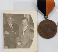 BLACK AND TAN MEDAL AND PHOTO OF GENTLEMAN WEARING SAME